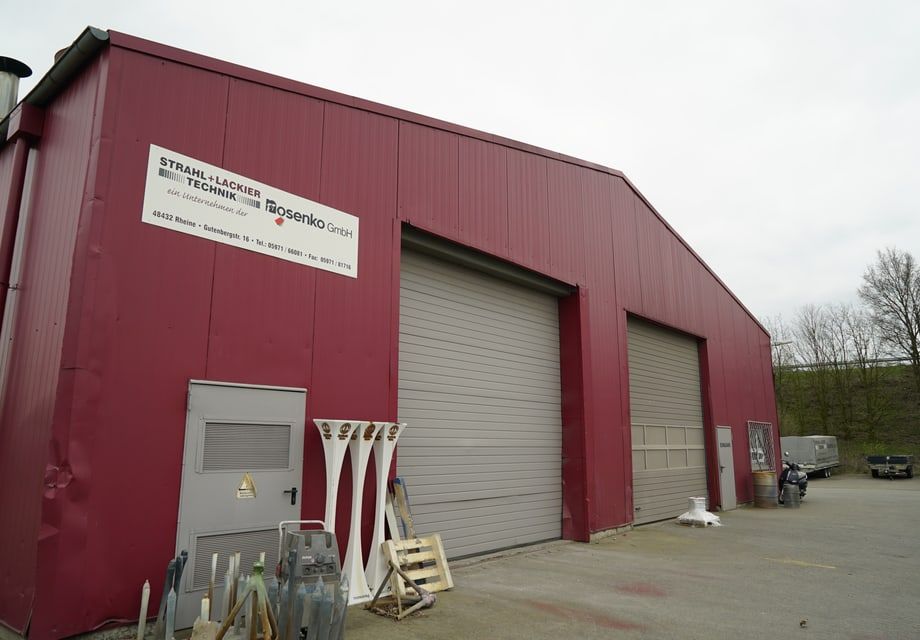 Halle des Betriebs in Rheine von außen, Einfahrtstore bei Tageslicht.