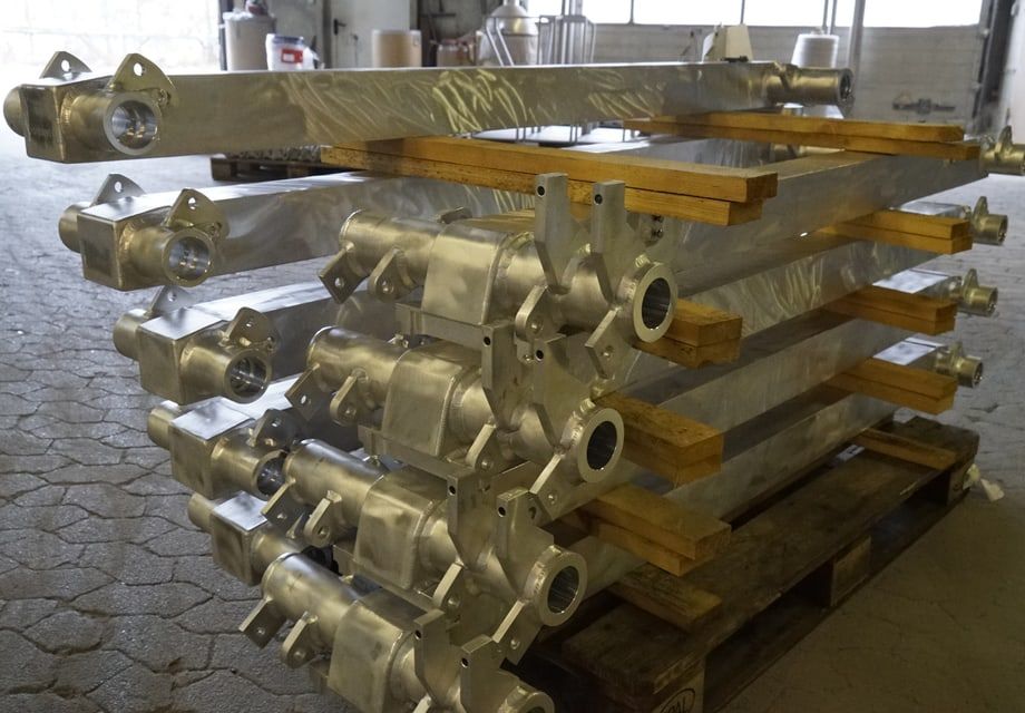 Mehrere gleichartige Hydraulikzylinder nach der Bearbeitung auf der Palette.